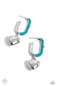 Featuring a solitaire white rhinestone embellishment, a silver heart charm swings from a glistening half turquoise-painted oblong silver hoop, creating a vivacious, charming display. Earring attaches to a standard post fitting. Hoop measures approximately 1" in diameter.  Sold as one pair of hoop earrings.