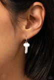 A small, skinny, silver hoop curves around the ear in a timeless fashion. A silver ball is affixed to the end of the hoop, reminiscent of a barbell fitting. A silver key charm slides along the curvature of the hoop, adding a subtle hint of industrial movement. Earring attaches to a standard post fitting. Hoop measures approximately 1/2" in diameter.  Sold as one pair of hoop earrings.