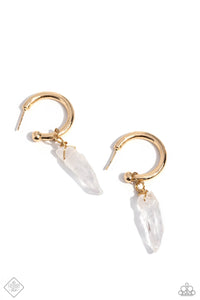 A small, skinny, gold hoop curves around the ear in a timeless fashion. A gold ball is affixed to the end of the hoop, reminiscent of a barbell fitting. Delicately attached to gold wire, a chiseled piece of clear white stone slides along the curvature of the hoop, adding a surprising hint of stony movement.