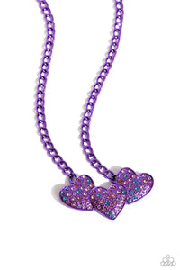 <p>Dipped in an electric purple hue, a strand of bulky chain gives way to three heart frames below the collar. Dotted with tactile electric purple studs, the interlocked heart frames feature various pink, blue, purple, and white rhinestones for a timeless finish. Features an adjustable clasp closure.</p> <p><i> Sold as one individual necklace. Includes one pair of matching earrings.</i></p>