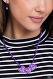 <p>Dipped in an electric purple hue, a strand of bulky chain gives way to three heart frames below the collar. Dotted with tactile electric purple studs, the interlocked heart frames feature various pink, blue, purple, and white rhinestones for a timeless finish. Features an adjustable clasp closure.</p> <p><i> Sold as one individual necklace. Includes one pair of matching earrings.</i></p>