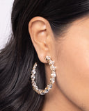 The front of a bold gold hoop is encrusted in glittery white rhinestones, creating a glamorous pop of sparkle. Earring attaches to a standard post fitting. Hoop measures approximately 2" in diameter.  Sold as one pair of hoop earrings.