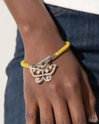 Embellished in yellow rhinestones, a mesh chain loops around the wrist, connecting through a silver toggle clasp. A yellow and iridescent-encrusted airy silver butterfly flutters below the yellow chain for a whimsically light finish. Features a toggle clasp closure. Due to its prismatic palette, color may vary.  Sold as one individual bracelet.