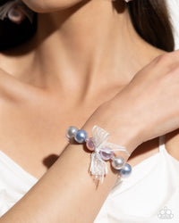 <p>Strung along an elastic stretchy band, a collection of glossy colorful pearls alternate with dainty white pearls along the wrist. An airy, chiffon white ribbon is tied in the center of the pearls for a refined finish.</p> <p><i> Sold as one individual bracelet. </i></p> <br><b> Get The Complete Look! </b> <br>Earring: "Elegance Ease - Multi" (Sold Separately)