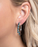 Infused with glistening blue zircon, aquamarine, light peach, and olive rhinestones a thin silver hoop encircles the ear. Pressed in silver-pronged fittings emerald-cut blue gems delicately swoop asymmetrically along the silver hoop for additional glitz, completing the demurely layered look. Earring attaches to a standard post fitting. Hoop measures approximately 1 1/2" in diameter.  Sold as one pair of hoop earrings.