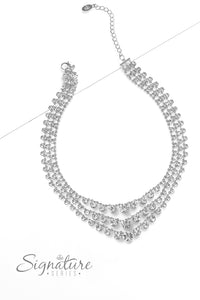 Rows of glittery, white rhinestones drape between two sleek silver bars, falling into three luxurious layers. The sparkling gems gradually increase in size as they fall towards the center of the design, adding dazzling dimension to the twinkling tiers. Features an adjustable clasp closure.  Sold as one individual necklace. Includes one pair of matching earrings.