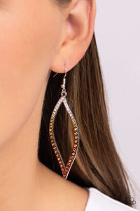 A glistening asymmetrical silver leaf-like frame is encrusted in glassy white rhinestones that gradually fade from brass to copper, creating a colorful ombre effect for a statement-making look. Earring attaches to a standard fishhook fitting.