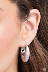 <p>Featuring a thick surface, an elongated silver hoop curls around the ear for a sleek basic look. Earring attaches to a standard hinge closure fitting. Hoop measures approximately 3/4" in diameter.</p> <p><i> Sold as one pair of hinge hoop earrings.</i></p>